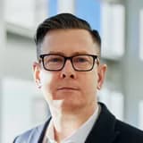 Mark, a finance director wearing glasses in a professional headshot