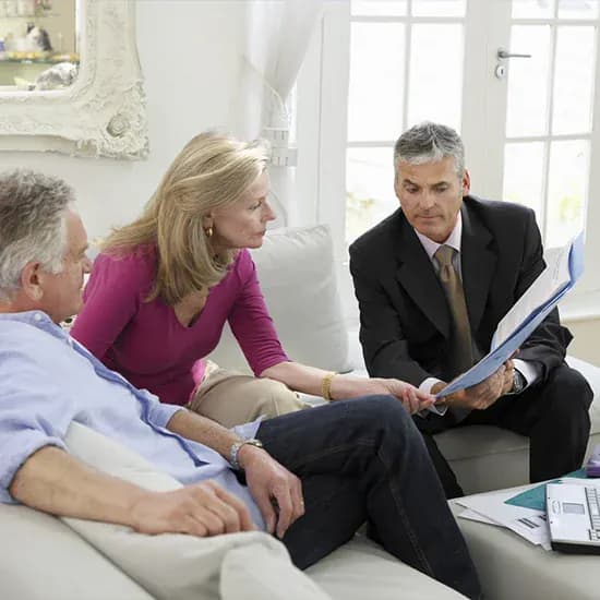 Private equity adviser reviewing documents with clients in a meeting