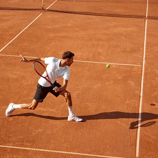Tennis player serving on an outdoor clay court